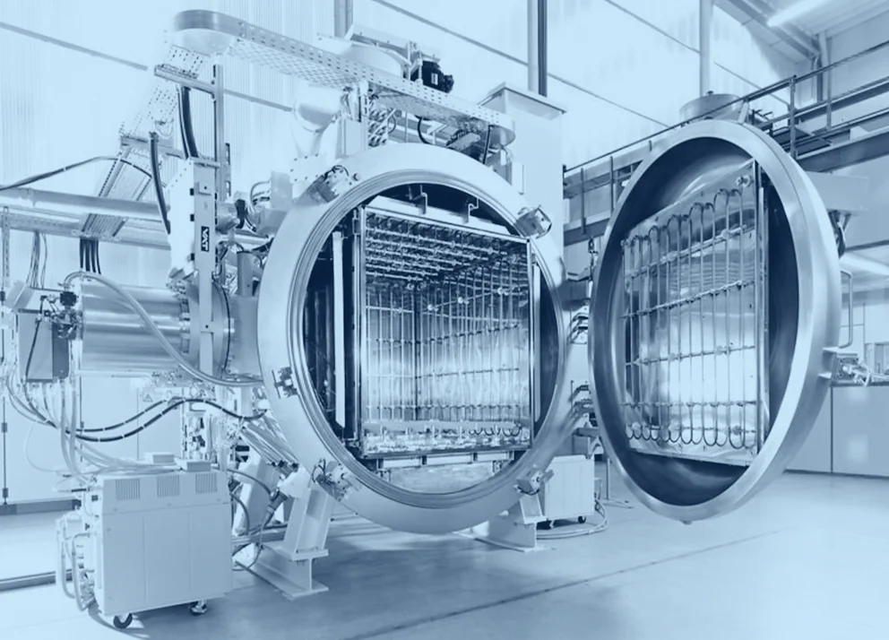 "Open vacuum brazing furnace with a large cylindrical chamber and visible internal heating elements inside an industrial facility