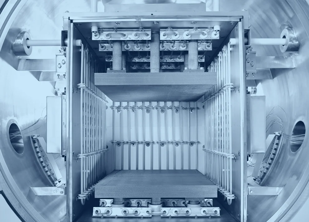 Open interior of a diffusion bonding furnace, showing the heating elements, pressure mechanisms, and chamber structure