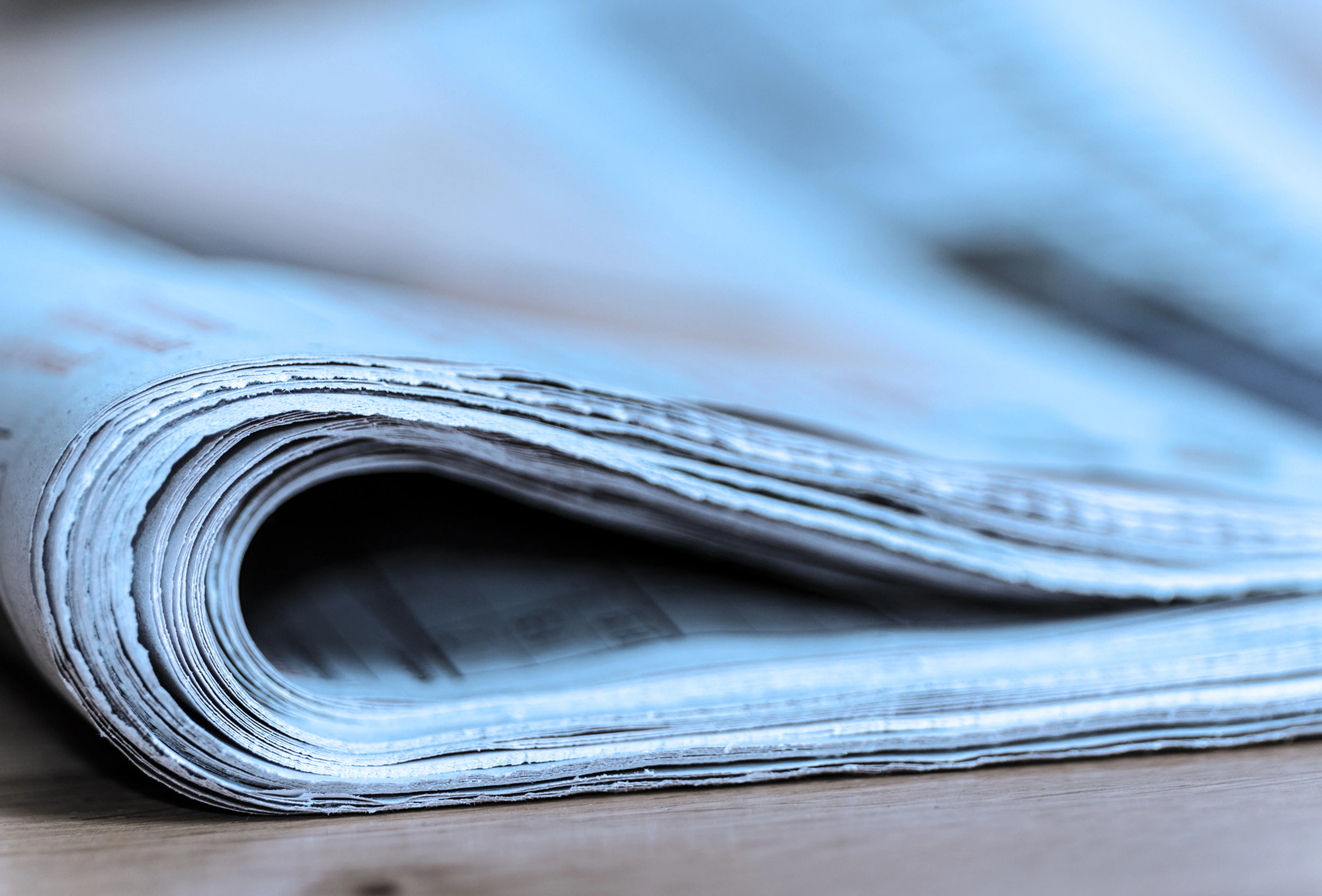 Close‑up of a folded newspaper on a table, symbolizing media or press