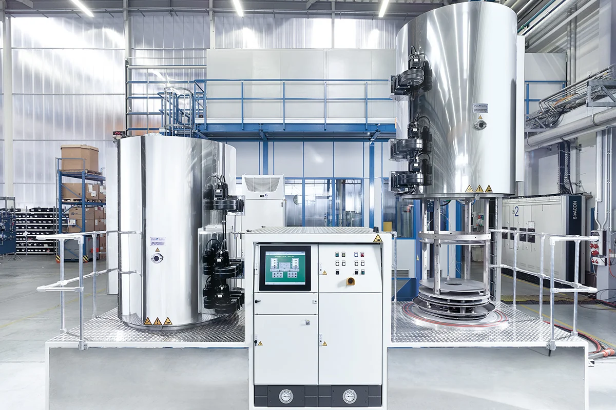 PulsPlasma® nitriding system in an industrial hall with control cabinet, tanks and piping